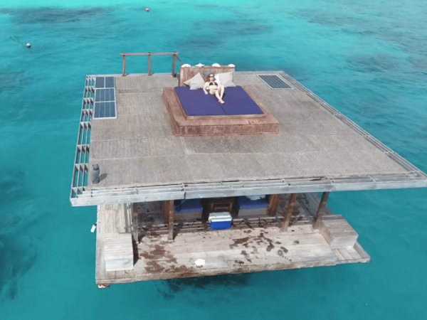 The Tanzania underwater hotel from above, with a woman lying on a bed on the upper deck