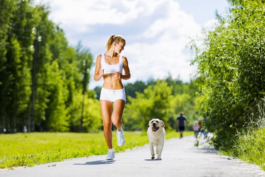 girl running in the park with her dog